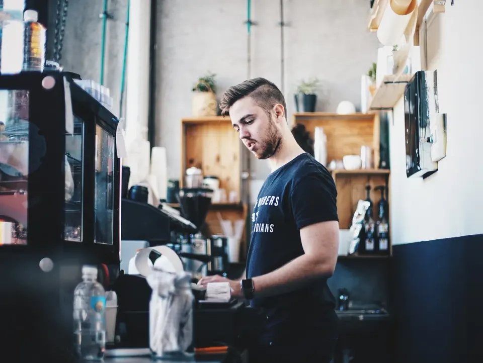 A cashier serving a customer across a shop counter