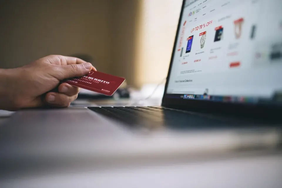 A shopper paying online with a credit card at a laptop